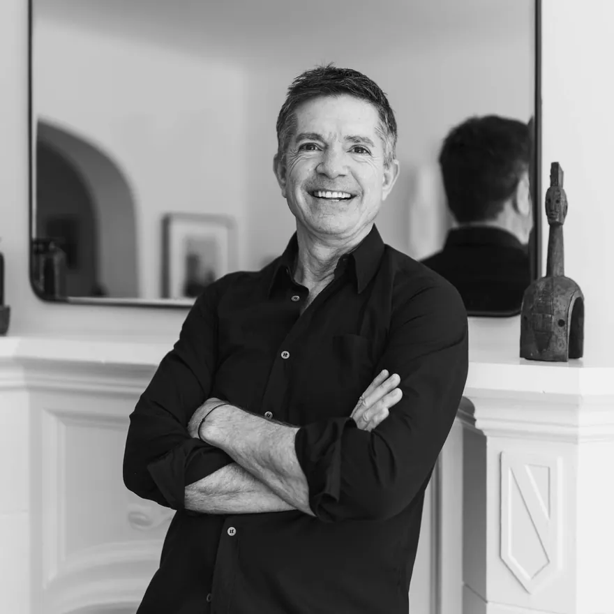 Charles Feuilherade, founder of THE EDIT, photographed in black and white with his arms folded beside a mantelpiece